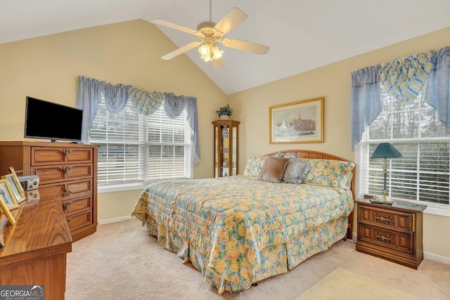 carpeted bedroom with vaulted ceiling, ceiling fan, and multiple windows