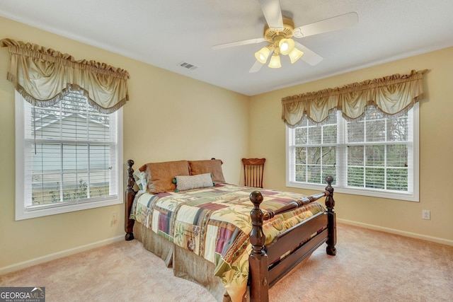 carpeted bedroom featuring ceiling fan and multiple windows