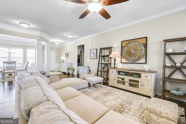 living room featuring visible vents, a ceiling fan, wood-type flooring, decorative columns, and crown molding