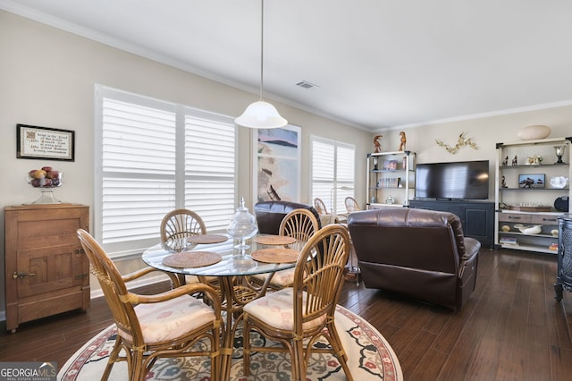 dining area with dark wood-style floors, visible vents, and crown molding