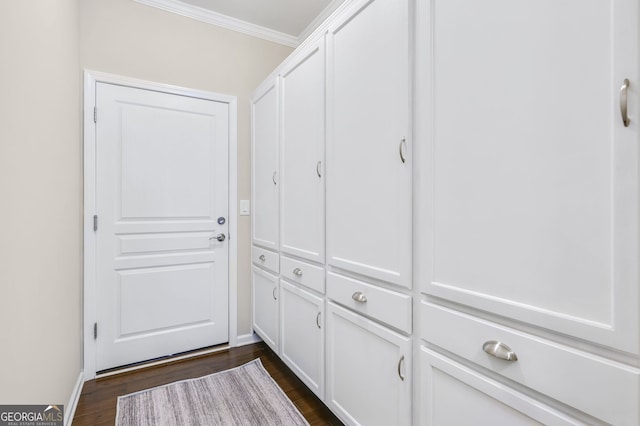 doorway to outside with ornamental molding, dark wood finished floors, and baseboards