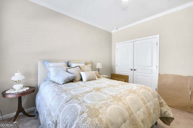 carpeted bedroom with lofted ceiling, a closet, ornamental molding, a ceiling fan, and baseboards