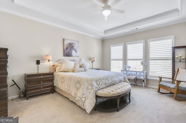 bedroom with light carpet, a tray ceiling, and crown molding