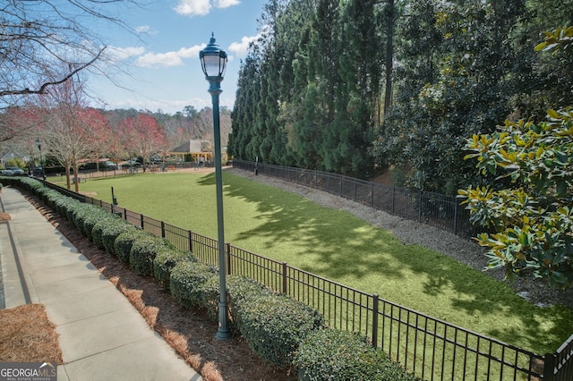 surrounding community featuring fence and a yard