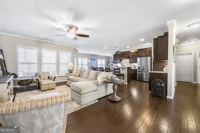 living area featuring baseboards, a ceiling fan, dark wood finished floors, and crown molding