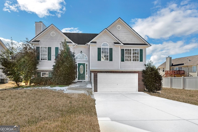 raised ranch featuring a front yard and a garage