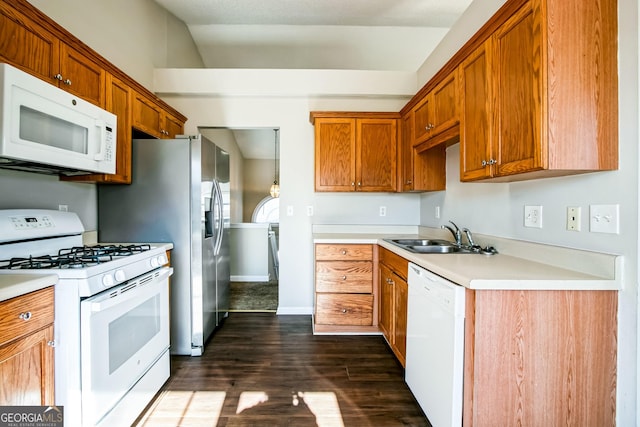 kitchen featuring dark wood-type flooring, sink, and white appliances