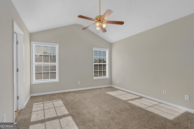 carpeted empty room with a textured ceiling, ceiling fan, and lofted ceiling