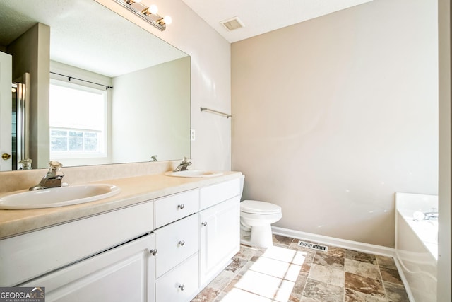 bathroom with a tub, toilet, and vanity