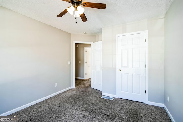 unfurnished bedroom featuring a textured ceiling, ceiling fan, a closet, and dark carpet