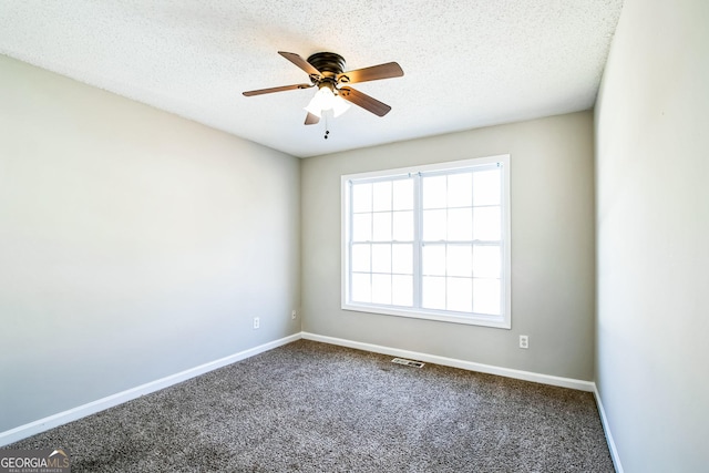 empty room featuring a textured ceiling, ceiling fan, and carpet