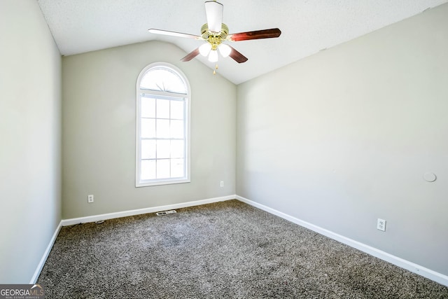 carpeted empty room featuring ceiling fan, a textured ceiling, and vaulted ceiling