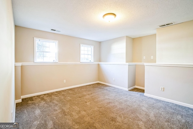 spare room with carpet floors and a textured ceiling