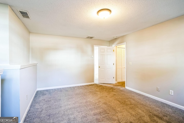 empty room featuring carpet floors and a textured ceiling