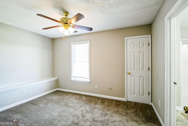 carpeted spare room with a textured ceiling and ceiling fan