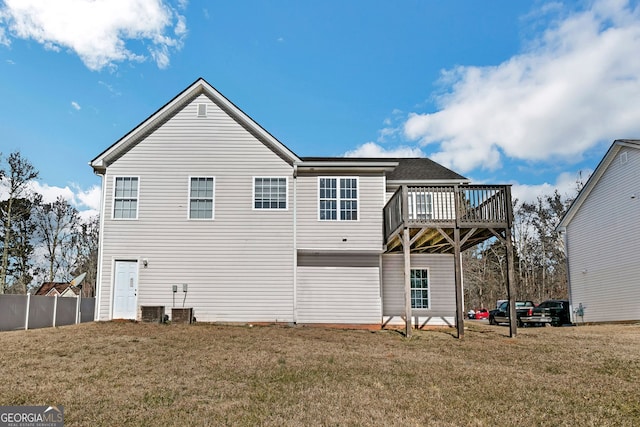 rear view of house featuring a lawn and a deck