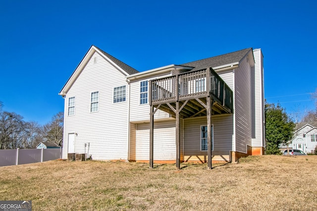 back of house with central AC unit, a deck, and a yard