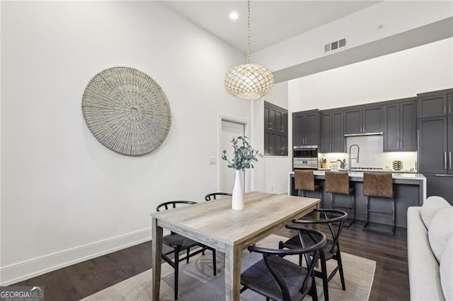 dining area featuring dark hardwood / wood-style flooring and high vaulted ceiling