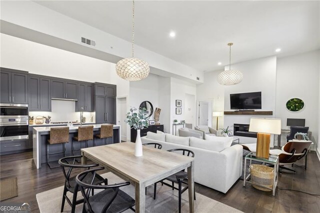 dining room with dark hardwood / wood-style flooring and a high ceiling