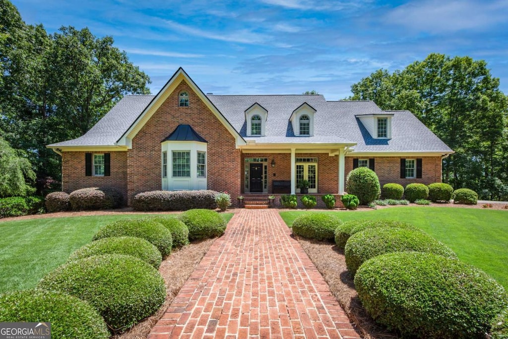 new england style home featuring a front lawn