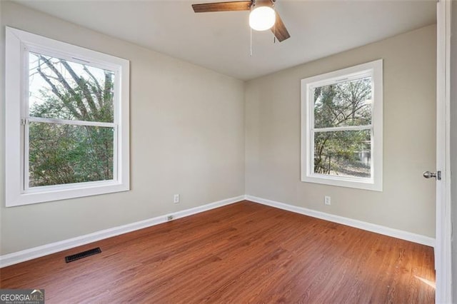 empty room with ceiling fan and hardwood / wood-style floors