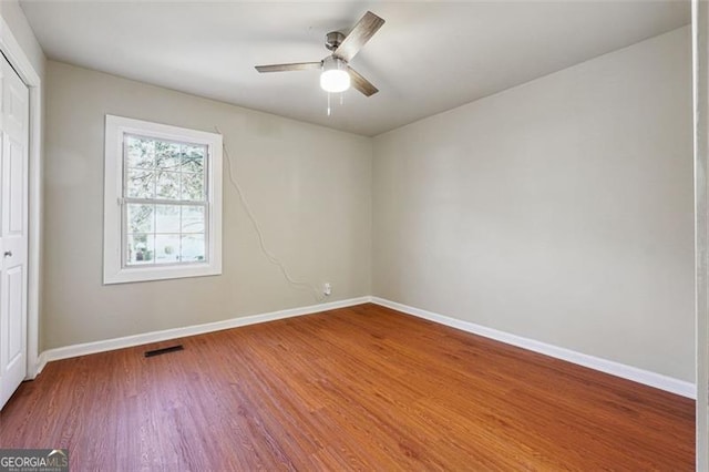 unfurnished room with ceiling fan and wood-type flooring