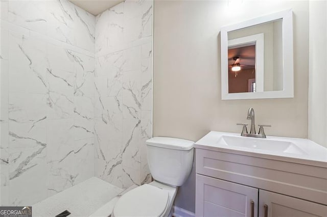 bathroom featuring toilet, vanity, and a tile shower