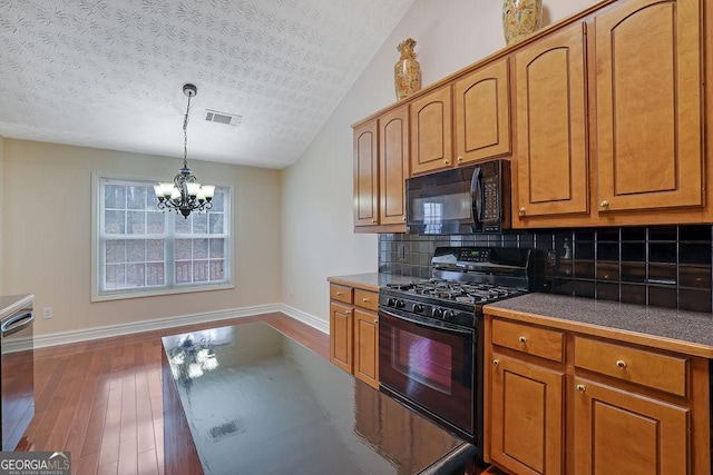 kitchen with black appliances, a textured ceiling, decorative backsplash, and an inviting chandelier