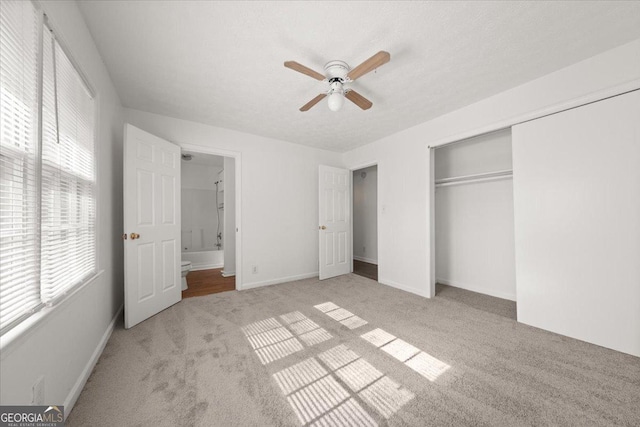 unfurnished bedroom with ceiling fan, light colored carpet, and a closet