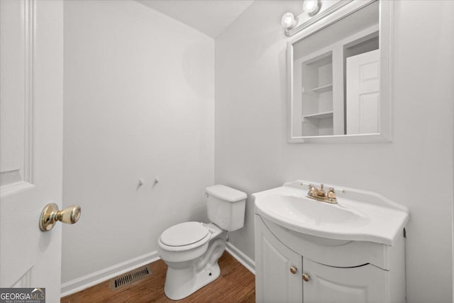 bathroom featuring hardwood / wood-style flooring, toilet, and vanity