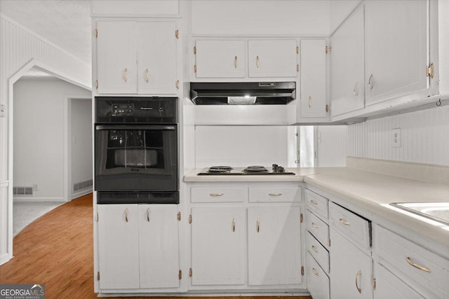 kitchen featuring black oven, white cabinetry, white gas stovetop, and light wood-type flooring