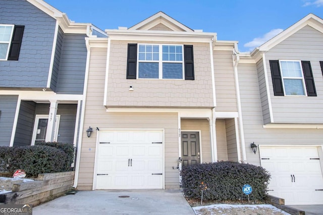 view of property featuring an attached garage and concrete driveway