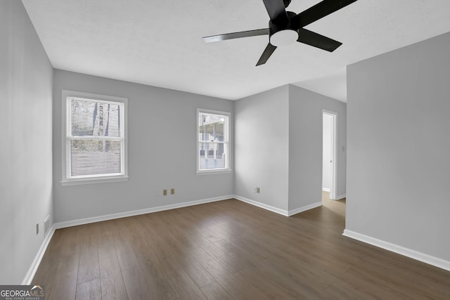 spare room featuring ceiling fan, plenty of natural light, and dark hardwood / wood-style floors