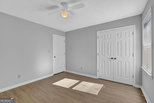 unfurnished bedroom with ceiling fan, a closet, and light hardwood / wood-style flooring