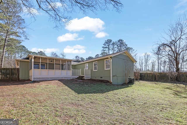 rear view of property featuring a lawn, central AC, and a sunroom