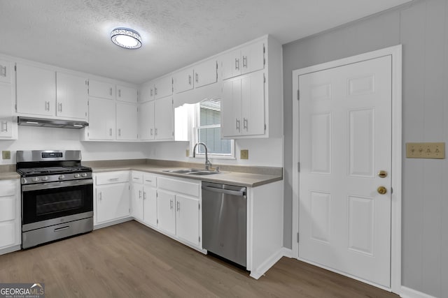 kitchen featuring a textured ceiling, appliances with stainless steel finishes, white cabinets, and sink