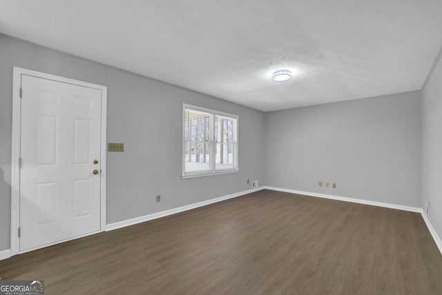 unfurnished room featuring dark hardwood / wood-style floors and a textured ceiling