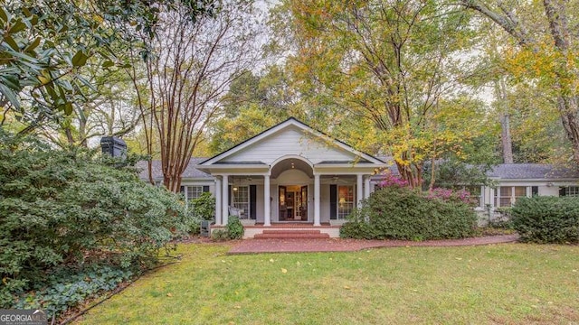 greek revival inspired property with covered porch and a front yard