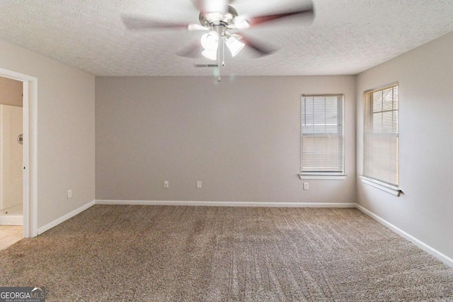 spare room featuring carpet floors, a textured ceiling, and ceiling fan