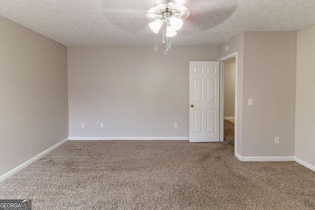 carpeted spare room featuring ceiling fan and a textured ceiling