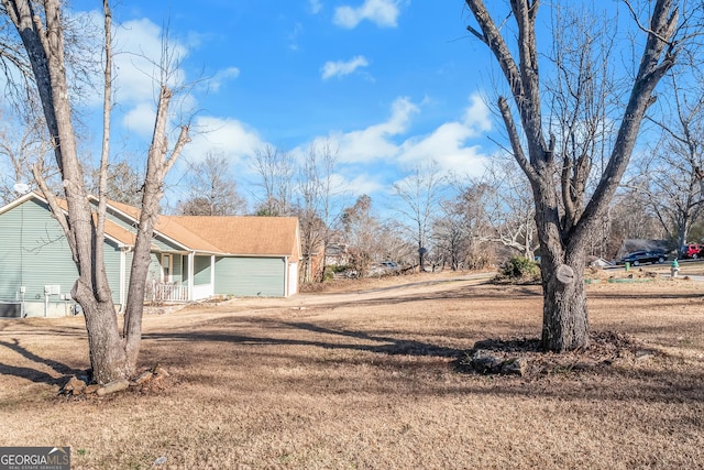 view of yard with a garage and central air condition unit