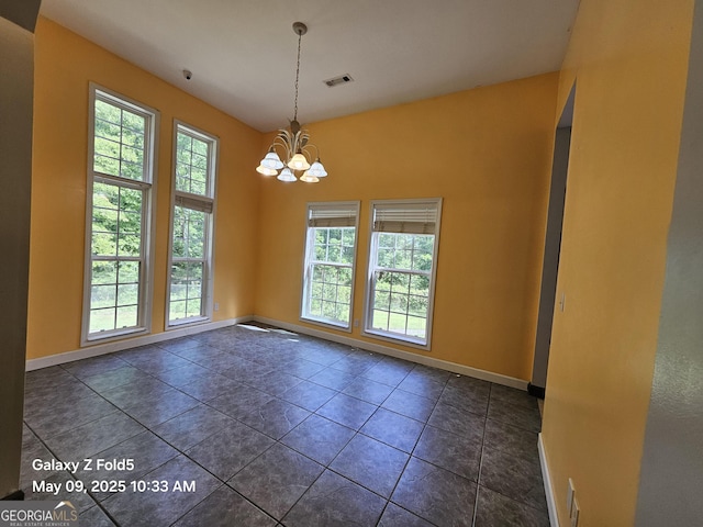 unfurnished room with baseboards and a chandelier