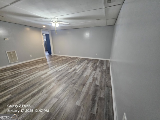 empty room featuring wood finished floors, a ceiling fan, and baseboards