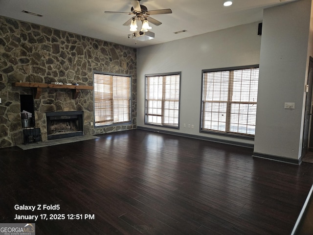 unfurnished living room with dark wood-type flooring, ceiling fan, and a fireplace