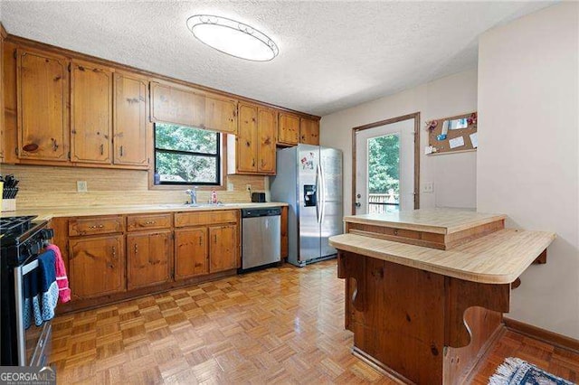 kitchen featuring light parquet flooring, sink, a wealth of natural light, and stainless steel appliances