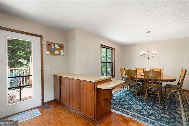 dining area with light parquet flooring, an inviting chandelier, and a textured ceiling