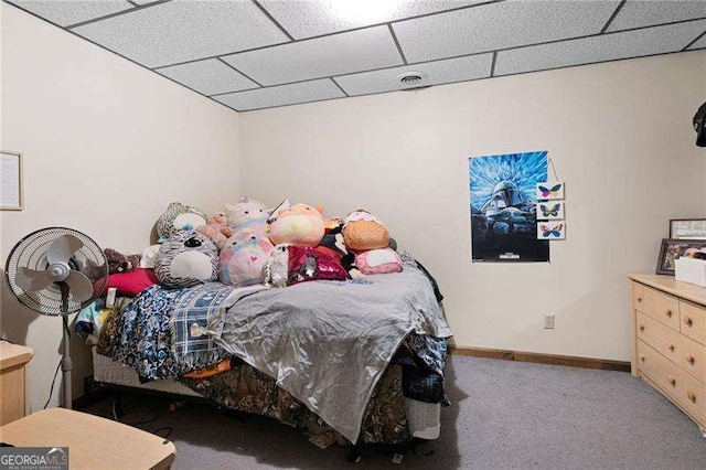 bedroom featuring carpet and a paneled ceiling