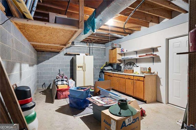 basement featuring white fridge with ice dispenser