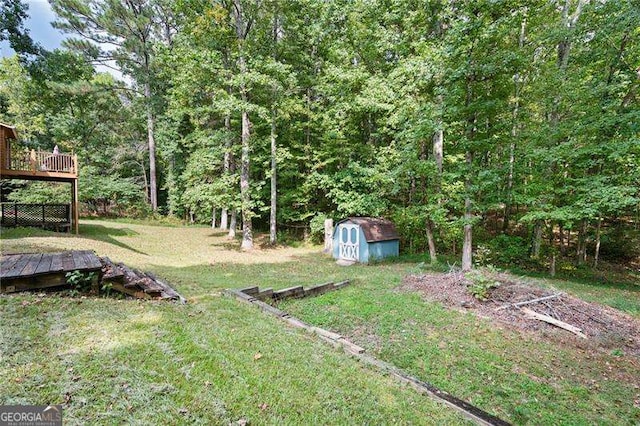 view of yard featuring a wooden deck and a storage unit