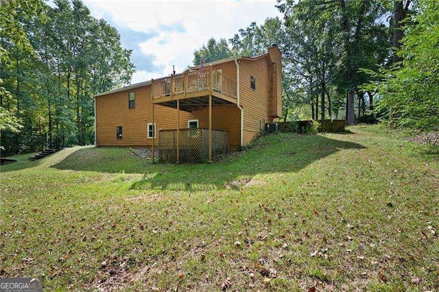 back of house featuring a deck, central air condition unit, and a lawn